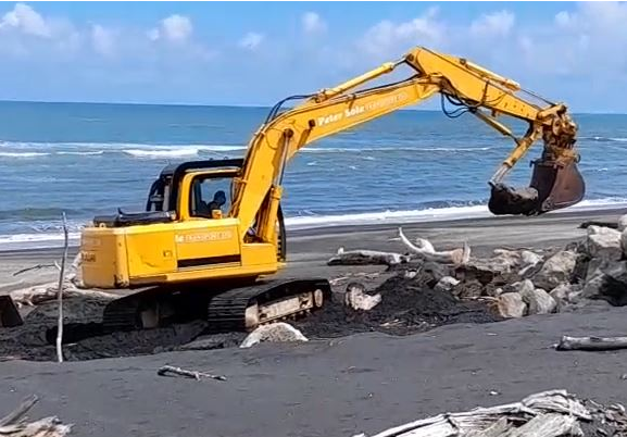 Digger on beach at Mōkau